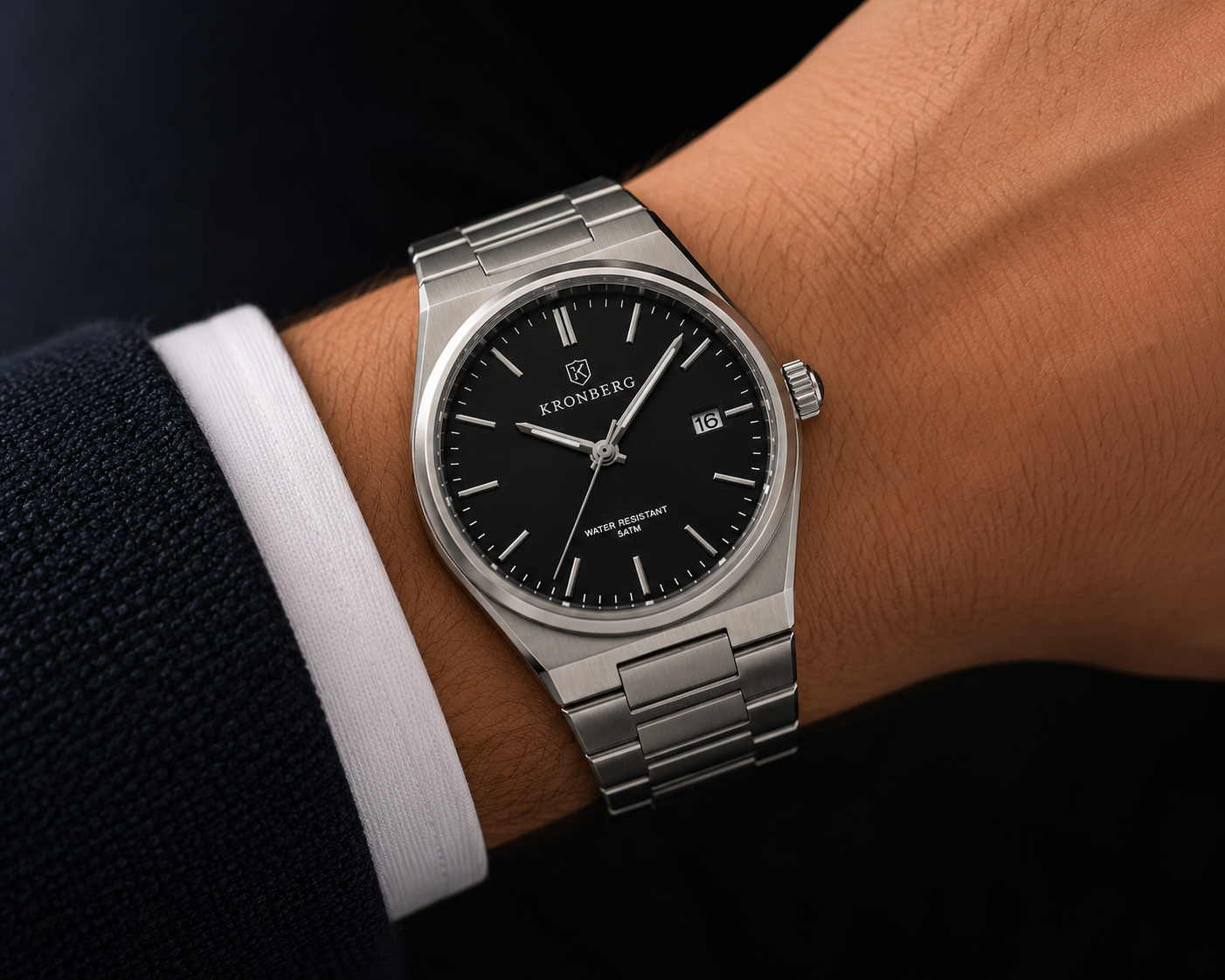 The Kronberg Classic worn on a wrist, under a shirt cuff and a navy jacket sleeve.